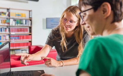 Zwei Frauen an Service-Theke der Bibliothek