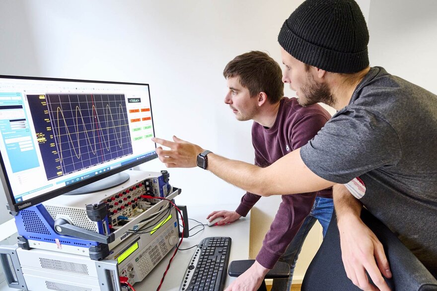 Zwei Doktoranden im Labor für Elektrische Maschinen, Leistungselektronik und Antriebe.