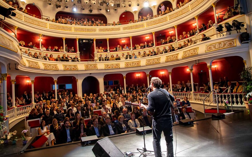 Musiker Chris Melon auf der Bühne des Stadttheaters mit Blick aufs Publikum