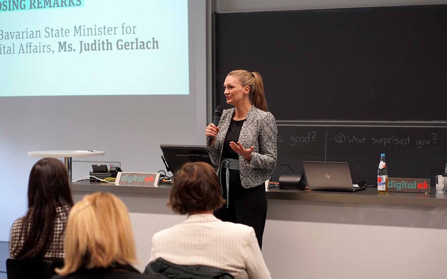 Frau spricht vor einem sitzenden Publikum