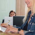 Studentinnen und Mitarbeiterin an der Theke des Dekanat WR