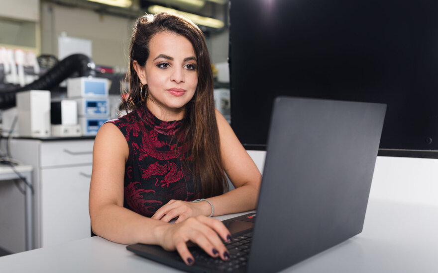 Eine Promovendin sitzt am Laptop und arbeitet im BioMEMS Lab der TH Aschaffenburg.