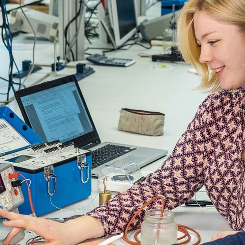 Studierende messen die Wassertemperatur im Glas mit Hilfe eines Thermowiderstands.