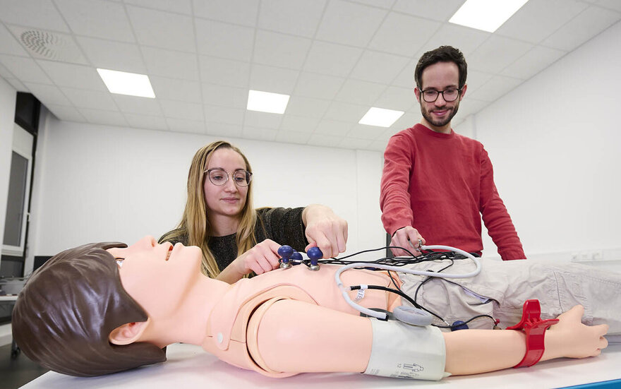 Studierende während einer Übung an einem lebensgroßen Puppensimulator.