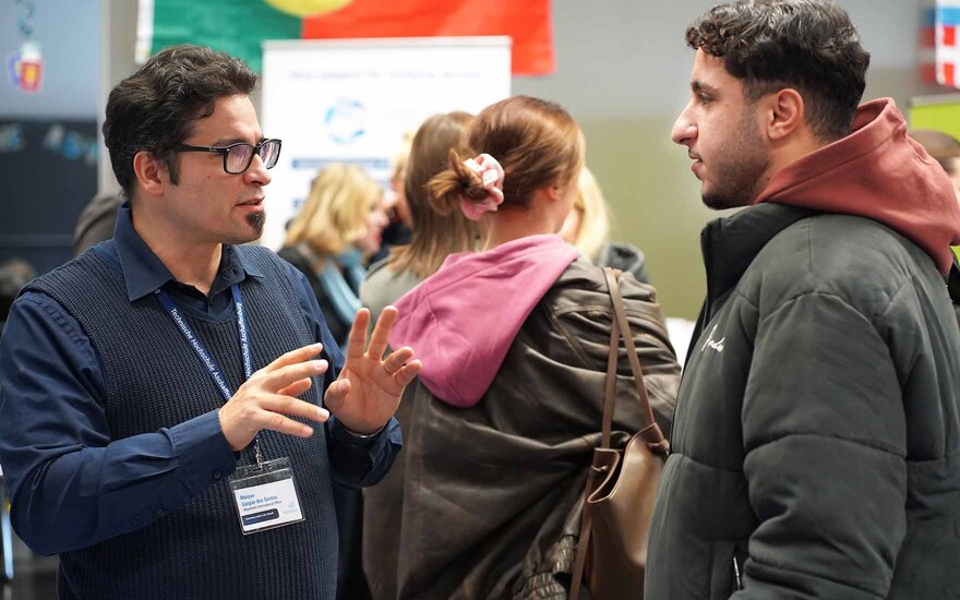 Ein Mitarbeiter des International Office berät einen Studenten beim International Day