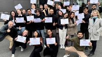 Gruppenfoto der Mercuri-Studierenden auf dem Campus mit Zertifikaten in der Hand