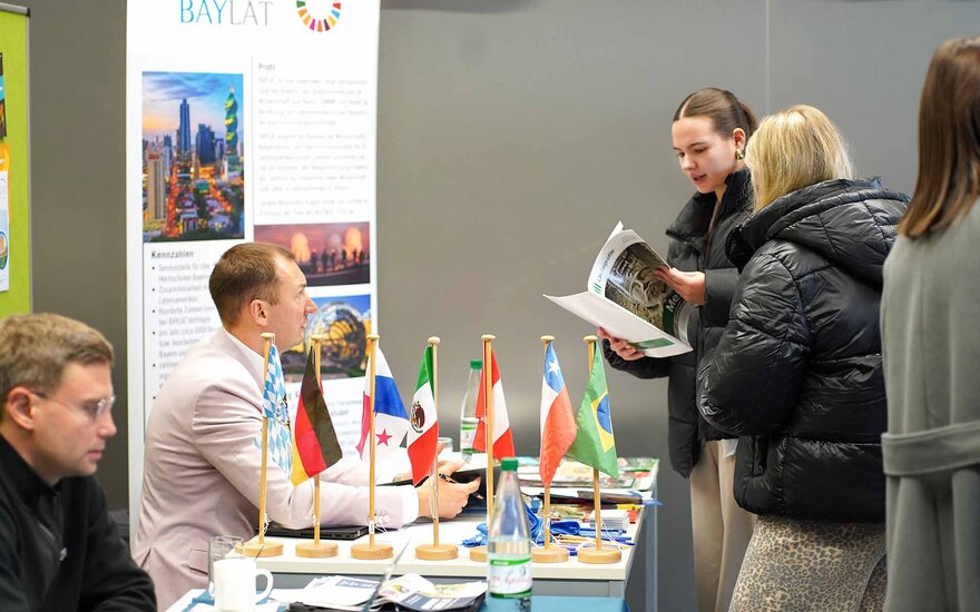 Studierende lassen sich an einem Informationsstand beim International Day beraten