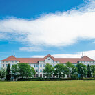 Campus-Wiese und Gebäude 20 am Campus 1 Hochschulgebäude der Technischen Hochschule Aschaffenburg, umgeben von Grünanlagen an einem sonnigen Tag.