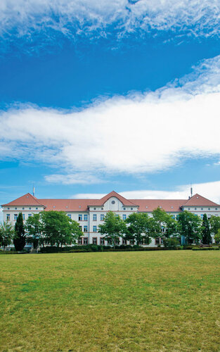 Campus-Wiese und Gebäude 20 am Campus 1 Hochschulgebäude der Technischen Hochschule Aschaffenburg, umgeben von Grünanlagen an einem sonnigen Tag.