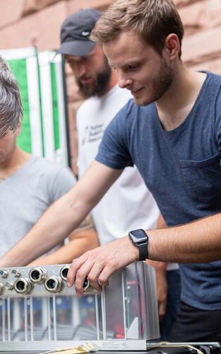 Studierende der Fakultät Ingenieurswissenschaften arbeiten zusammen mit einem Dozenten an einem Versuchsaufbau.