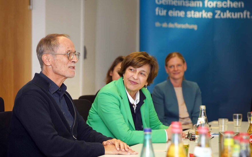 Die Präsidentin sitzt neben dem Spender Clemens Hensel und schaut ihn an.