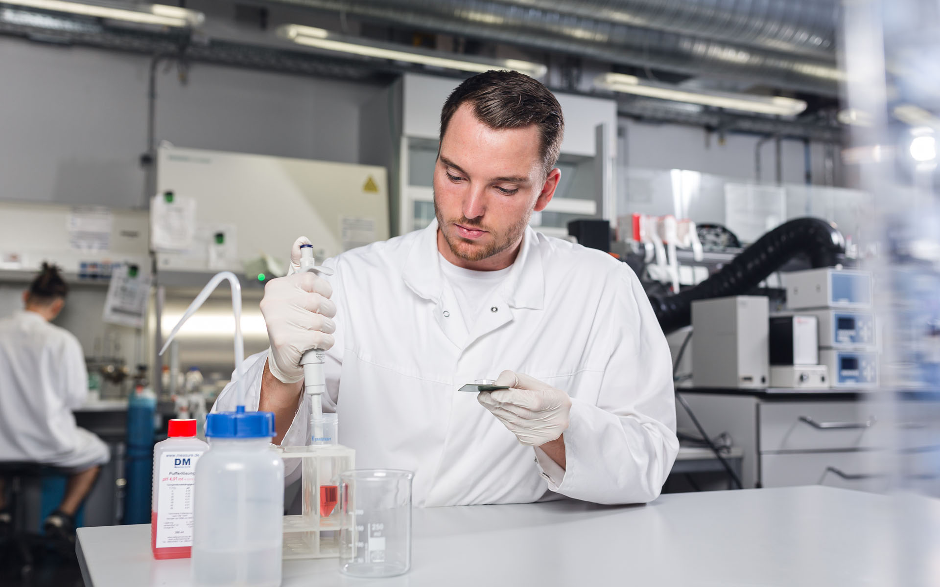 Ein Labormitarbeiter des BioMEMS Lab nimmt Flüssigkeit mit einer Pipette auf. 