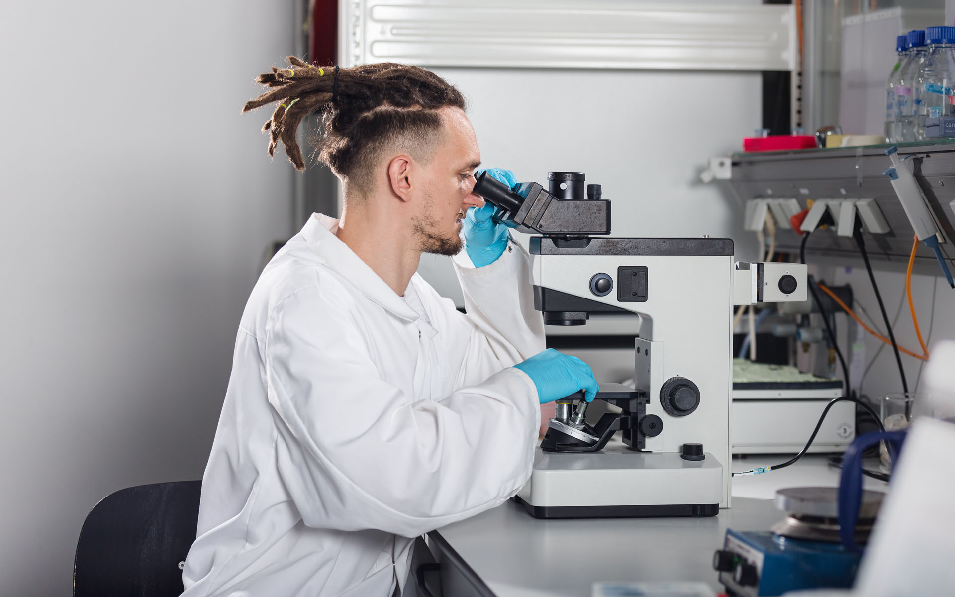 Ein Labormitarbeiter des BioMEMS Lab schaut durch ein Mikroskop.